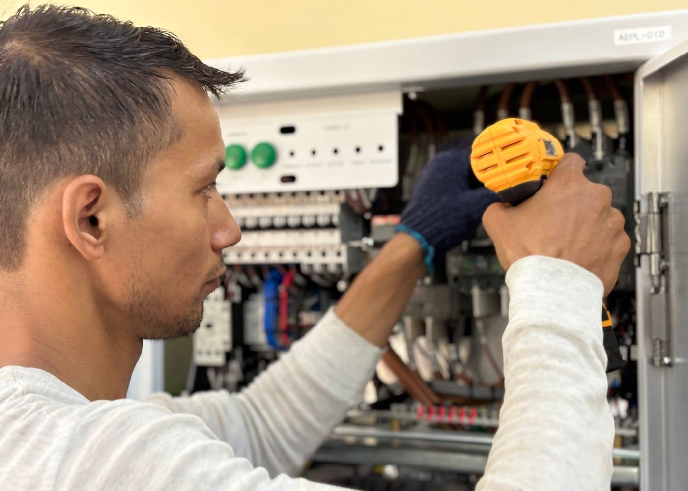 Elektriker arbeitet an einem geöffneten Verteilerschrank